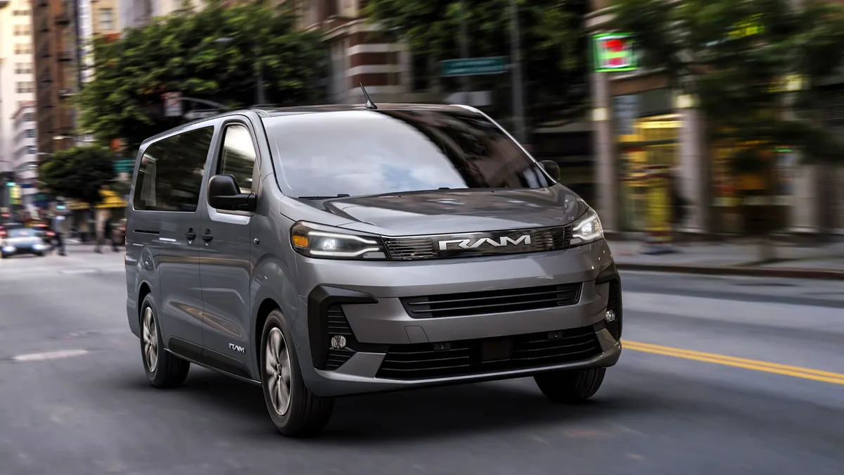 A gray Ram ProMaster City van moves along a congested American street.