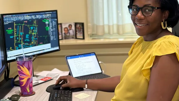 a woman works at a computer while seated at a desk