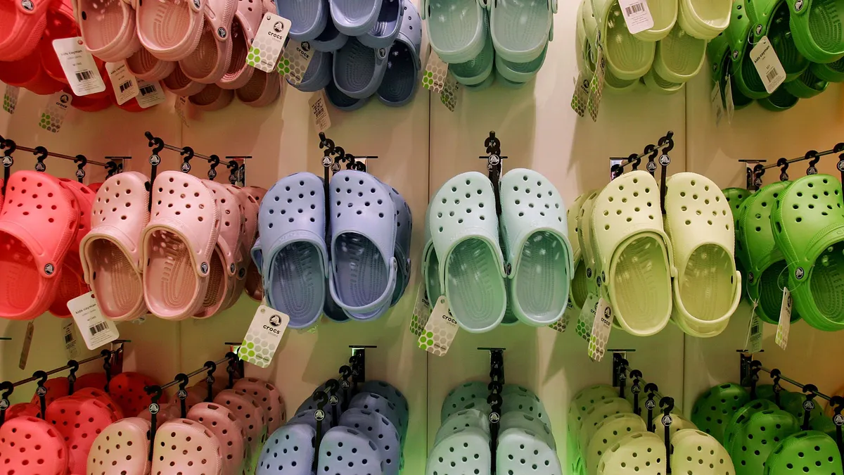 Multiple rows of Crocs in different colors are seen in a store.