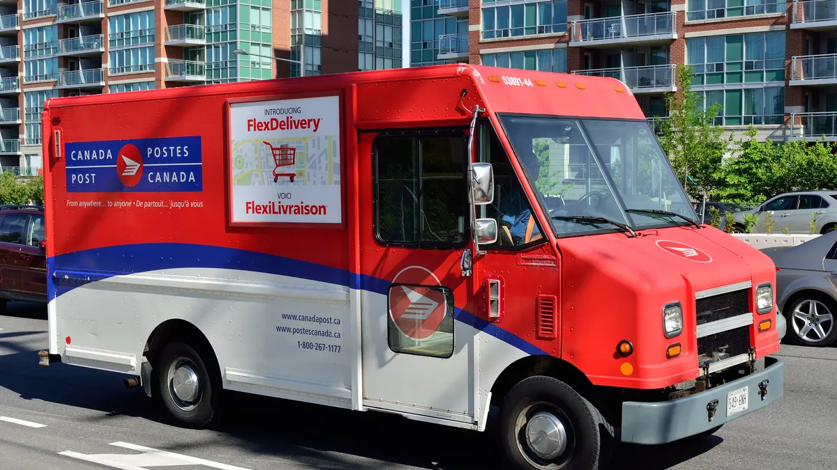 A Canada Post delivery truck on the road.