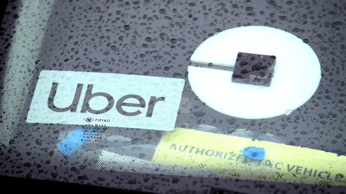 Closeup of an Uber sign on the rear window of a car in the rain.