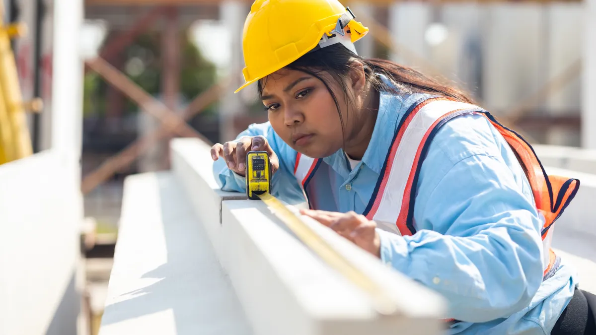 Female worker wearing safety hardhat inspec quality control at manufacturing factory.