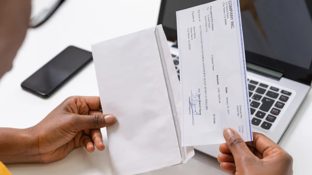 A person opens their paycheck.