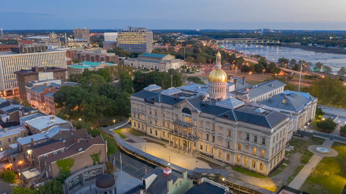 An aerial image of Trenton, Jersey shows the capital building and the surrounding area in the evening.