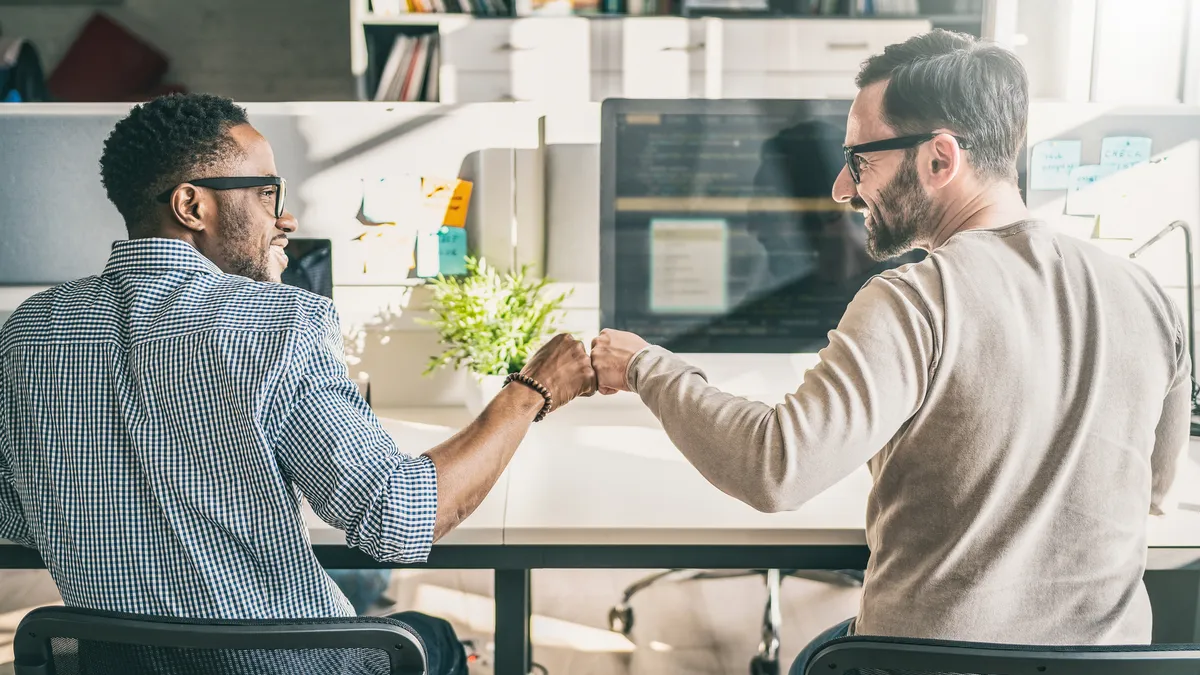 First bump between colleagues at work. Success in business. Everyday work in the office.