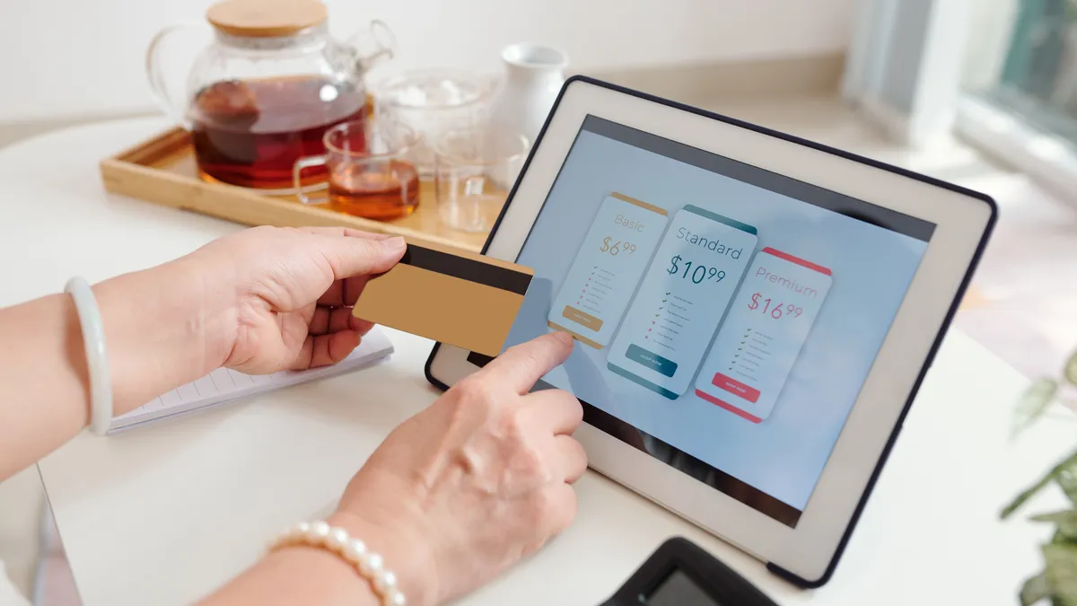 Woman's hand selecting subscription options on tablet screen