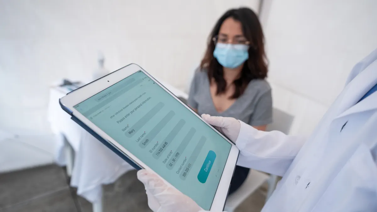 Young woman in a hospital being registered using a tablet computer