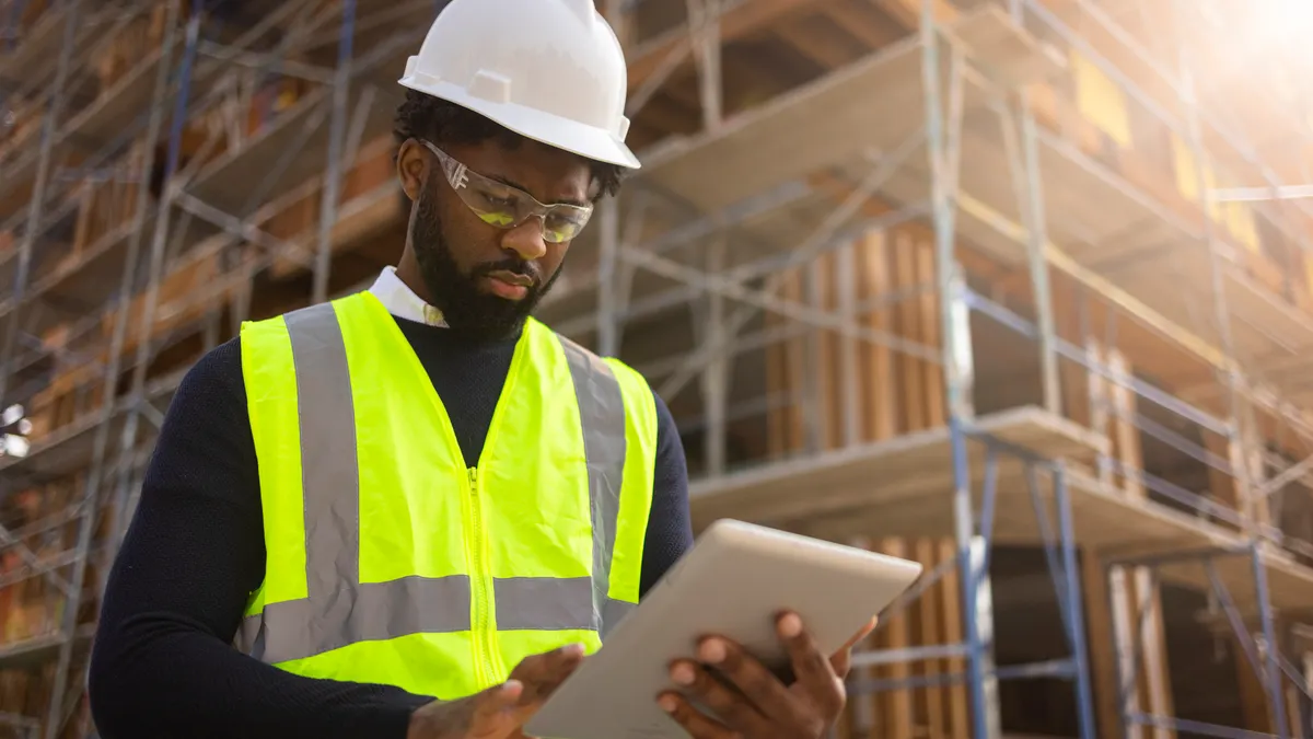 A young man is a project manager at a residential construction site.