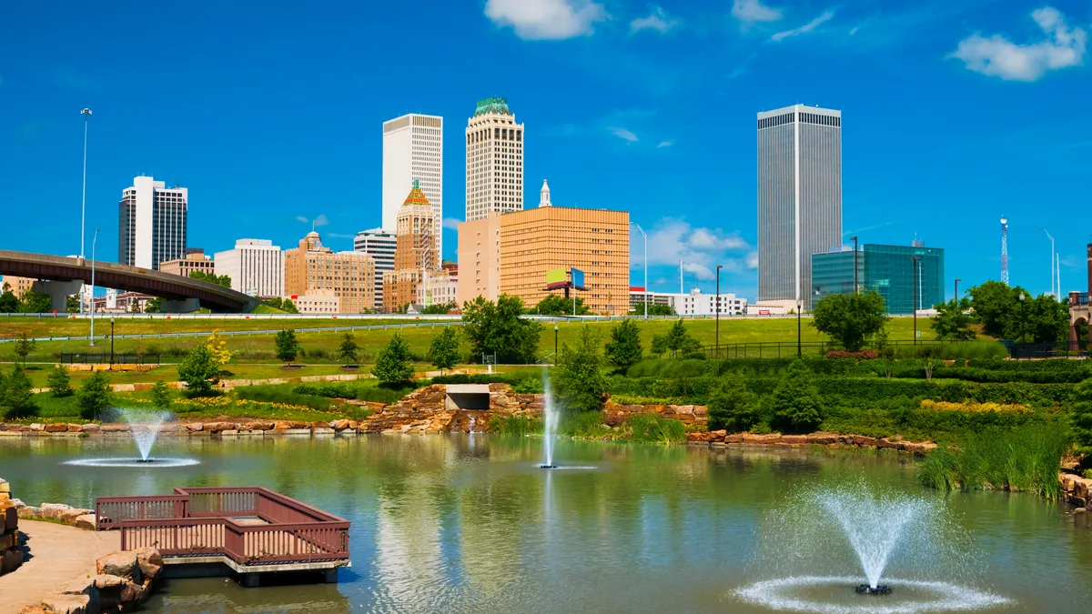 Tulsa skyline with a park, pond, and fountains in the foreground.