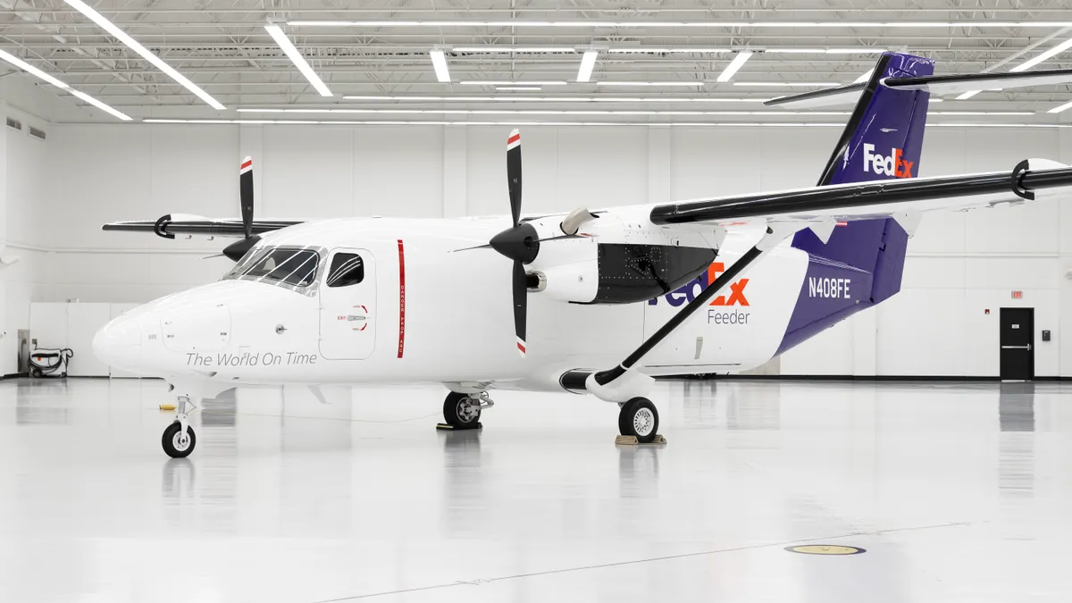 A FedEx-branded Cessna 408 SkyCourier aircraft sits in a hangar.