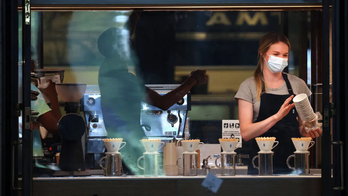 An employee wears a mask as they work in a coffee shop at Union Station on July 30, 2021 in Washington, DC.