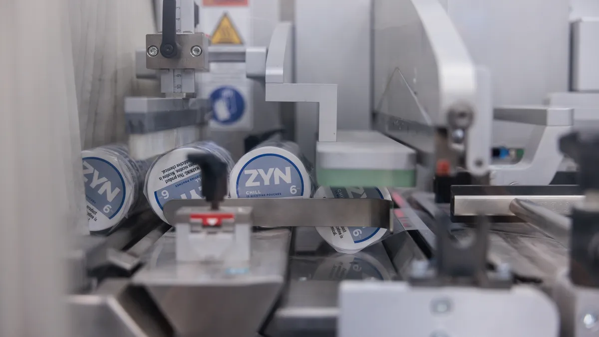 An image of a factory, processing hockey puck sized canisters that read "Zyn chill."