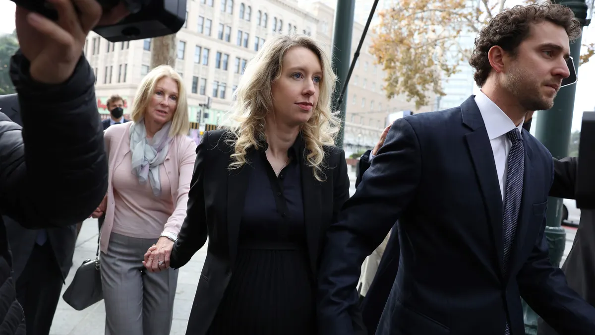 Former Theranos CEO Elizabeth Holmes (center) arrives at federal court with her partner Billy Evans and mother Noel Holmes on November 18, 2022 in San Jose, California.