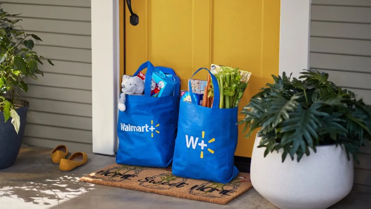 Two blue bags with groceries on a doorstep.