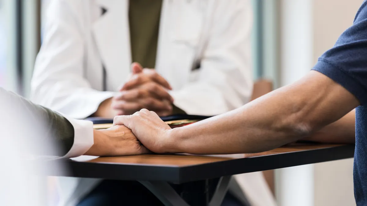 Two people hold hands at the doctor's office