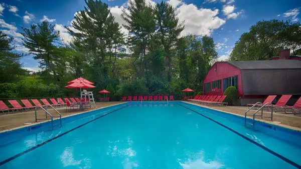 Apartment swimming pool surrounded by red chairs