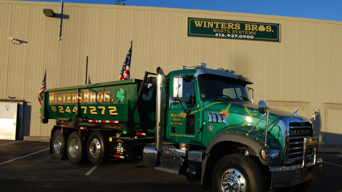 Winters Bros. Waste Systems truck in front of building with company logo