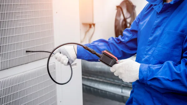 A technician uses a digital camera to inspect a heat exchanger.