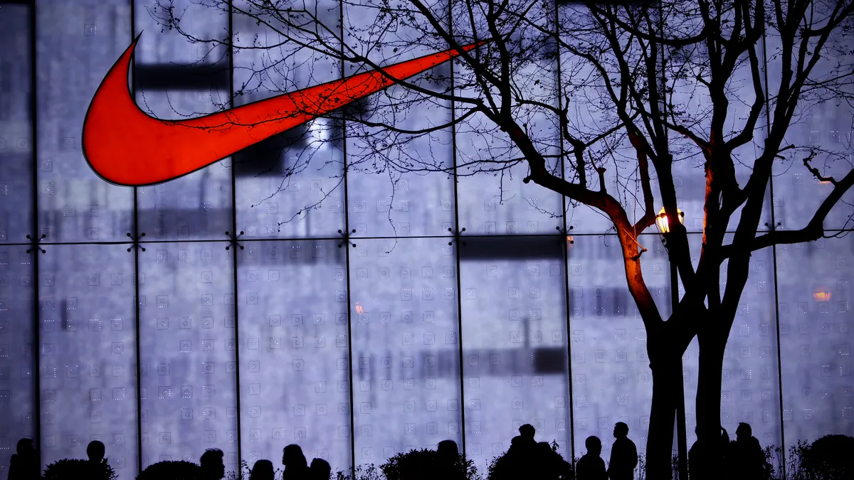 People walk by a Nike store.