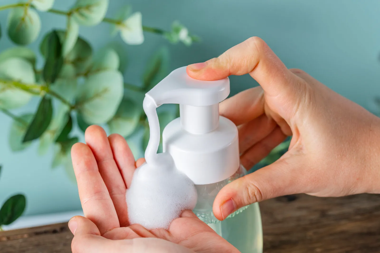 A person uses a foaming pump to dispense a product into their hands.