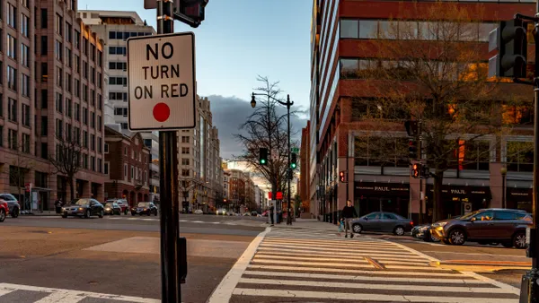 A view of an intersection along a busy city street with a sign, "No turn on red."