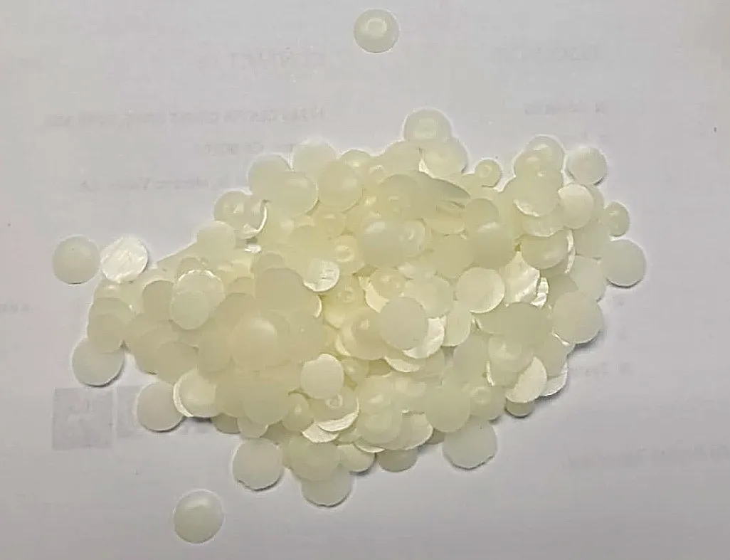 Close-up view of pelletized biobased material used for coating fiber packaging.