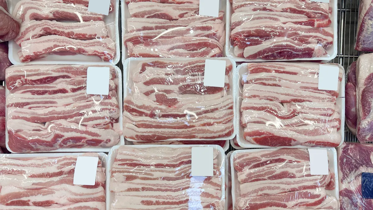 Bacon, or pork belly, packages on a retail display.