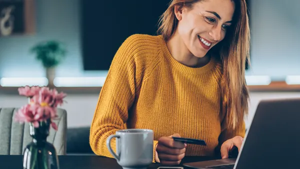 Young woman shopping online with credit card and lap top at home