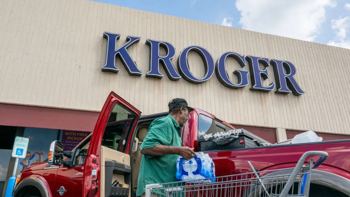 A shopper loads his truck in front of a Kroger.