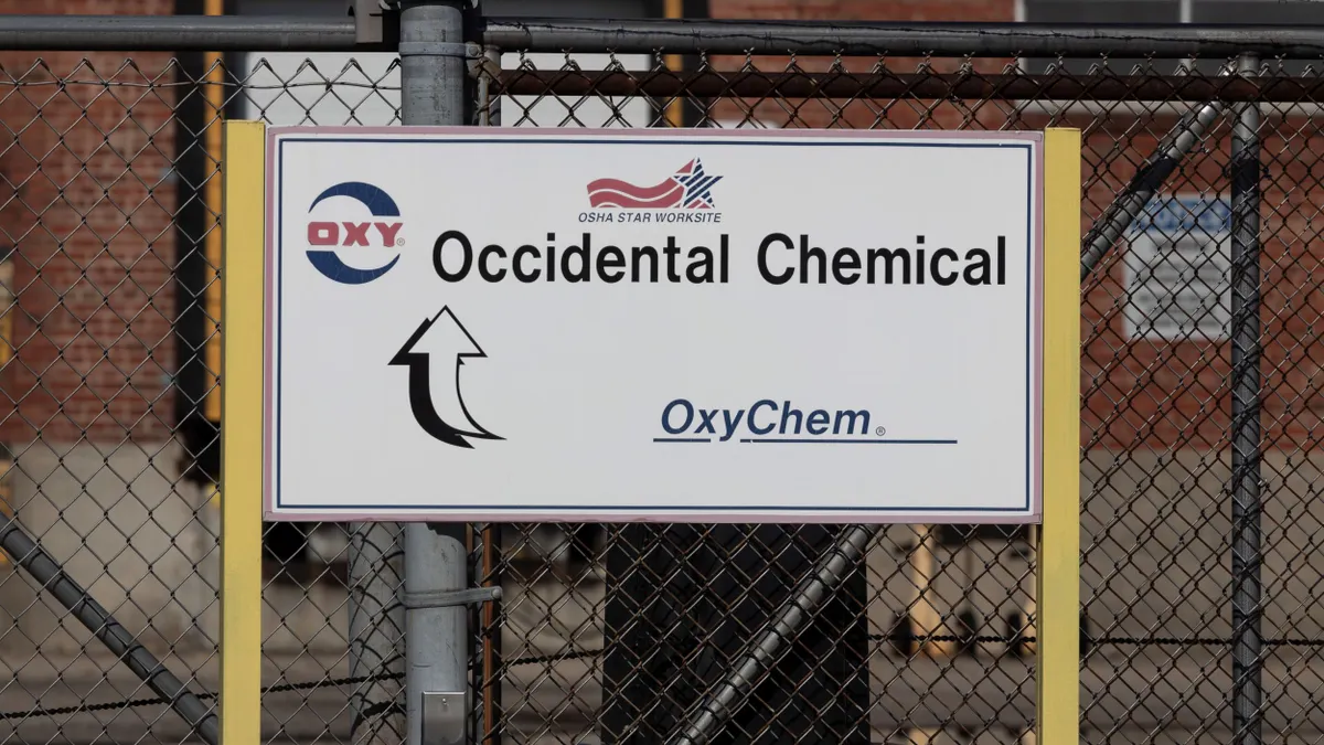 A white sign with "Occidental Chemical" in black text and "OxyChem" in blue text underneath it.