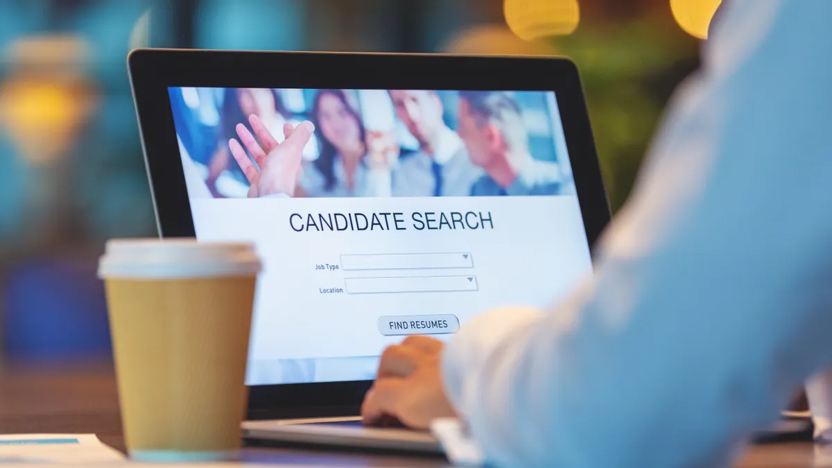 Businessperson looking at recruitment website on a laptop computer.