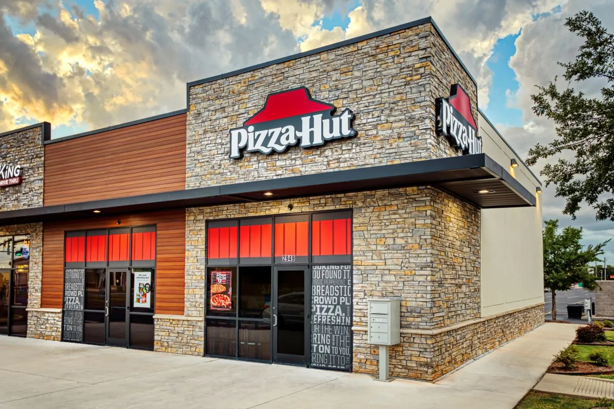 An exterior image of a Pizza Hut with bricks and red signage