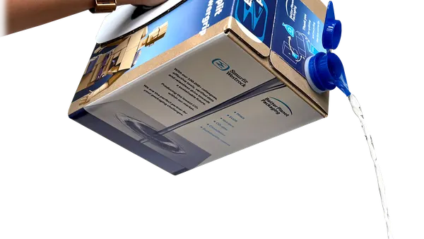 A person's hand holds a cardboard box via an integrated handle and pours fluid from a spout on the box.