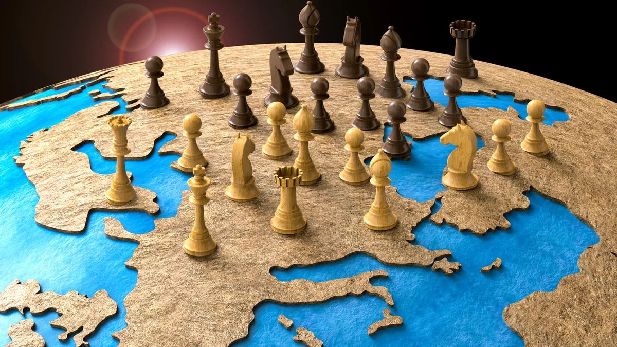 Chess pieces positioned on a globe representing the planet earth.