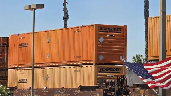 Schneider National orange containers onboard a rail train.