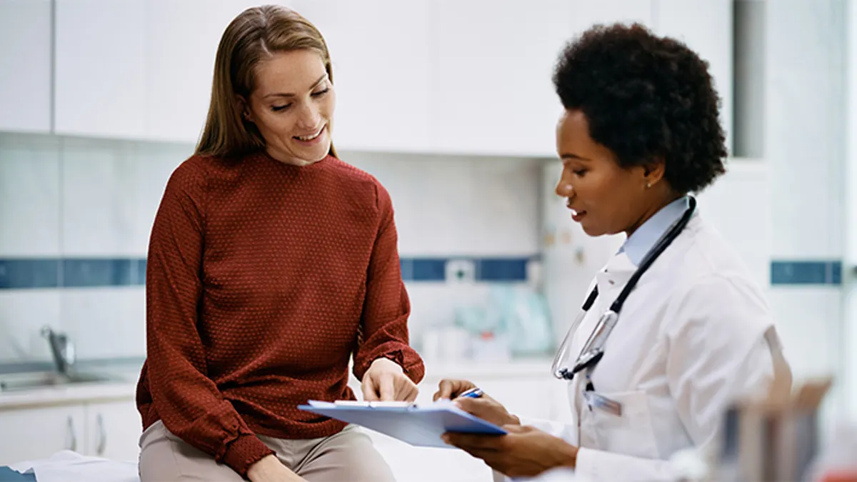 A doctor meeting with a smiling patient.