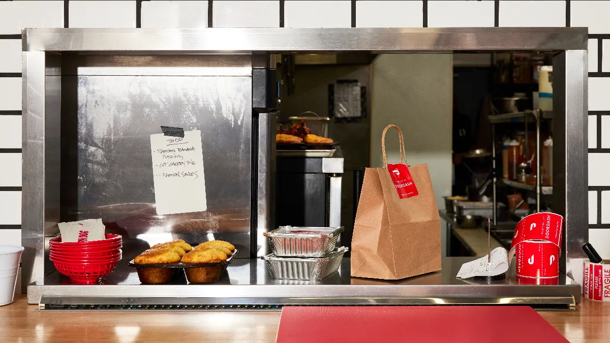 An image of a kitchen counter with DoorDash orders ready for pickup.