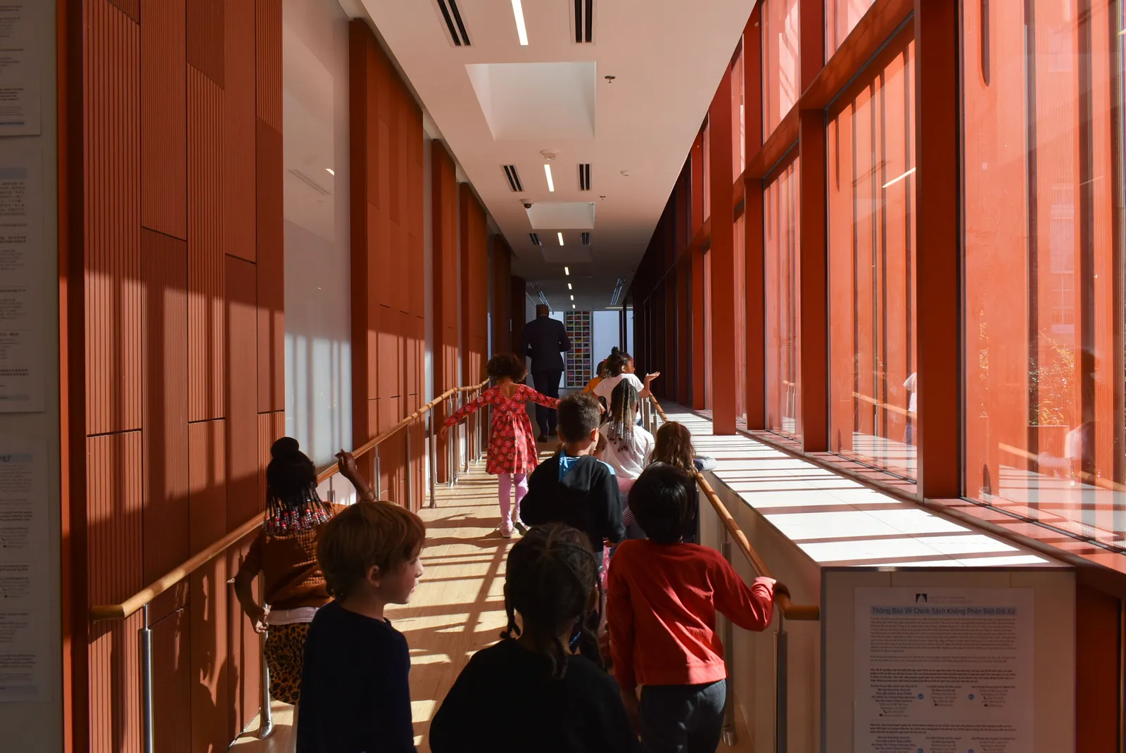 A group of schoolchildren walk through a hallway lined with windows on Oct. 28, 2024. Their backs are toward the camera.