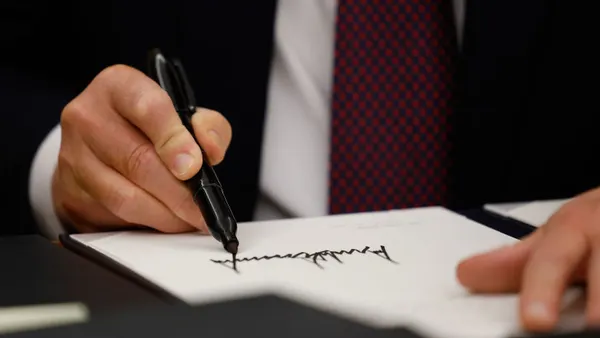 Trump holds up a signed execuitve order