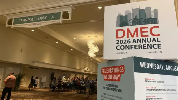 DMEC sign in convention center with people walking by