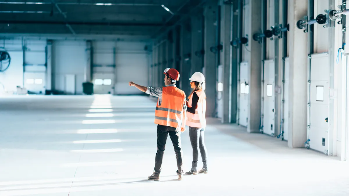 Two facilities management workers inspect a building.