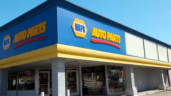 A corner of a storefront with windows with a sign that reads "Napa Auto Parts"