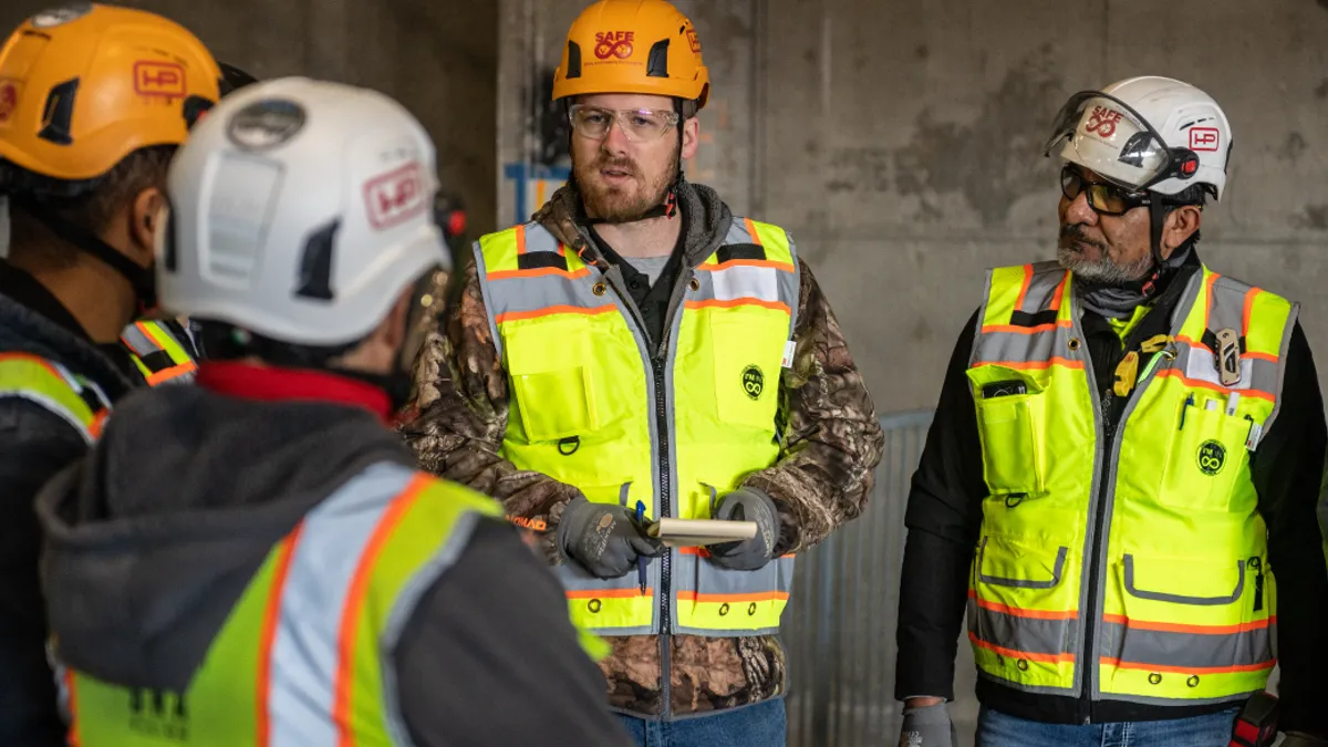 Three construction workers discussing plan