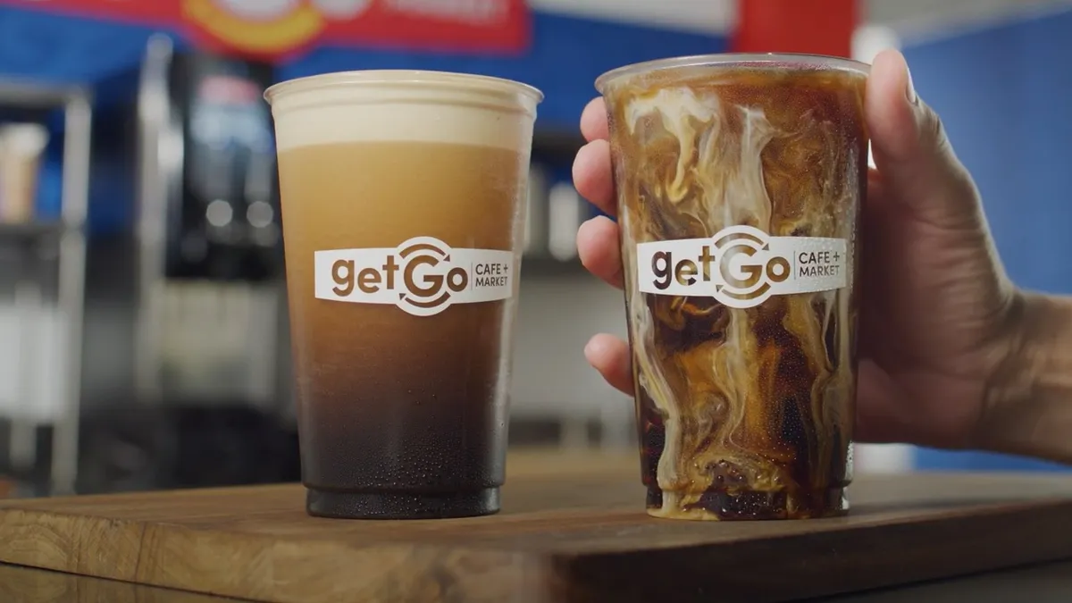 A photo of two cups of GetGo coffee with a hand holding one.