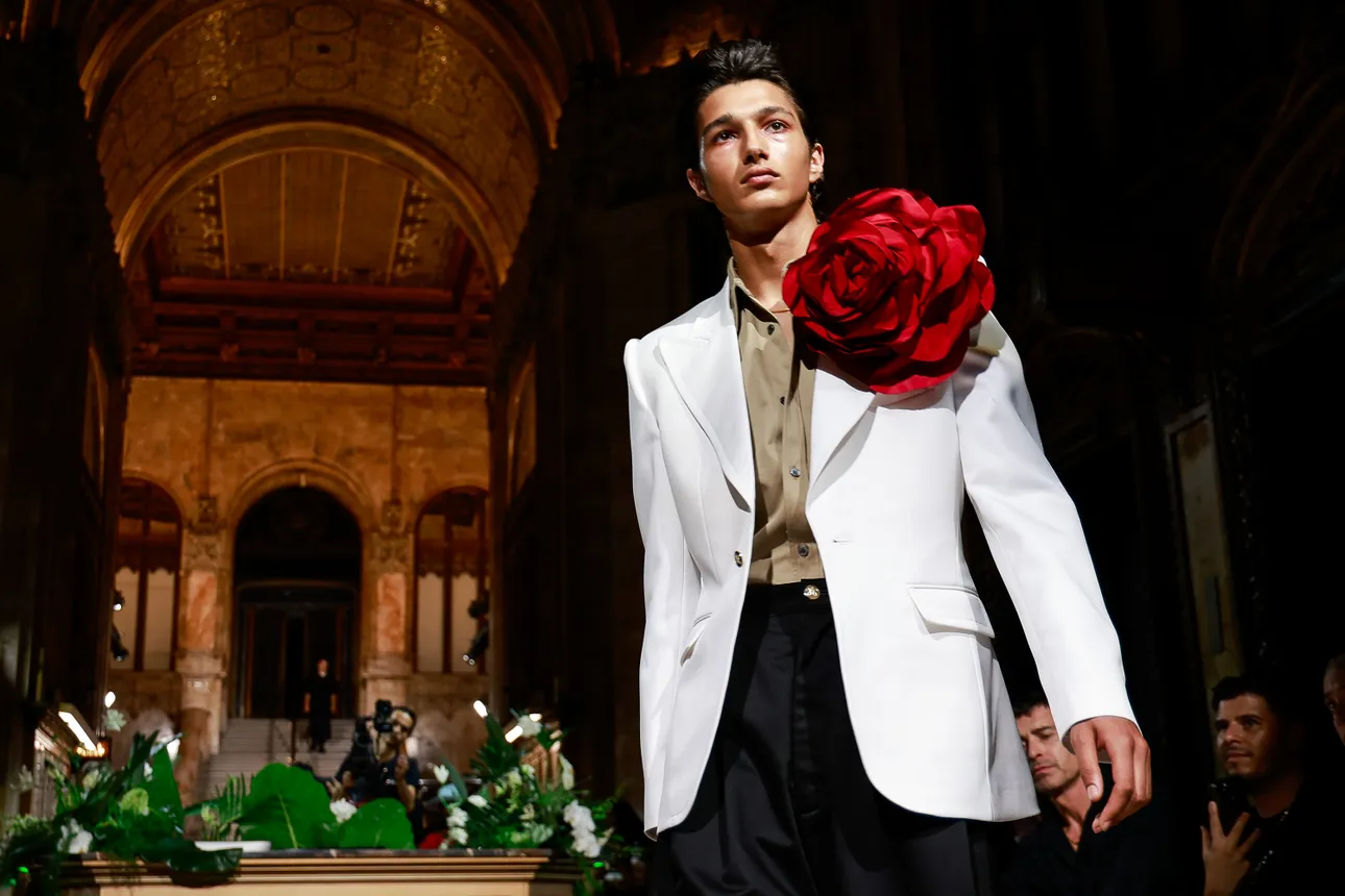 A model in a white suit jacket with a giant red flower on the lapel walks the runway during the Willy Chavarria fashion show during New York Fashion Week on September 13, 2023.