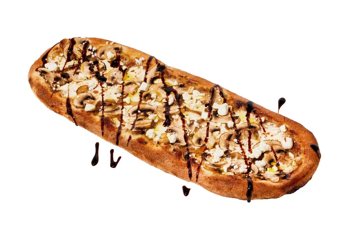 An image of a pizza with a mushroom truffle drizzle, mushrooms and onions