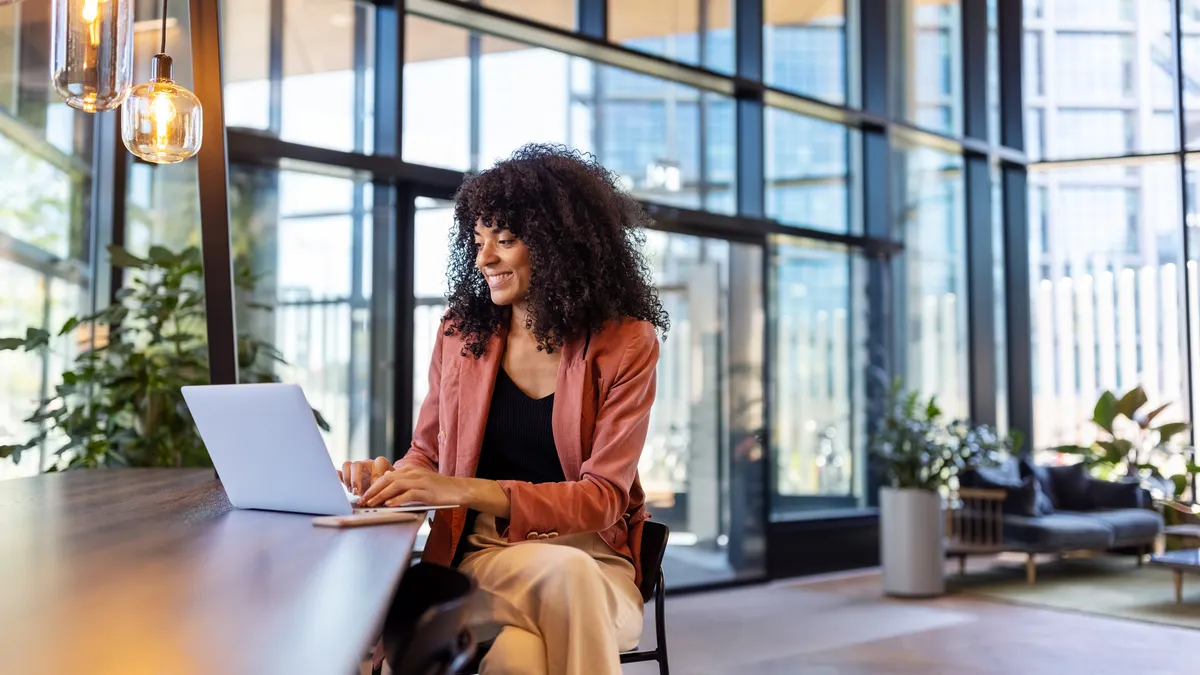 Happy young woman working on laptop