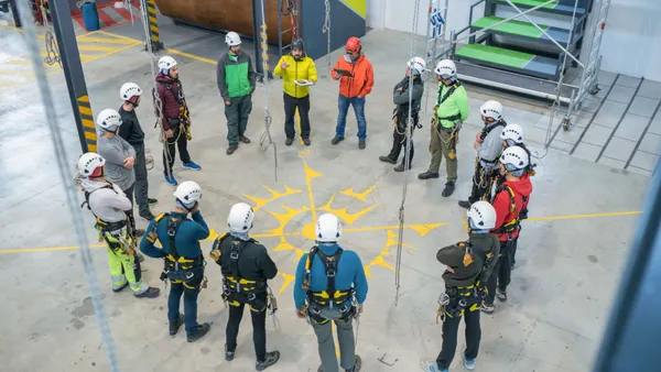 A group of construction workers standing in a circle for a jobsite meeting.