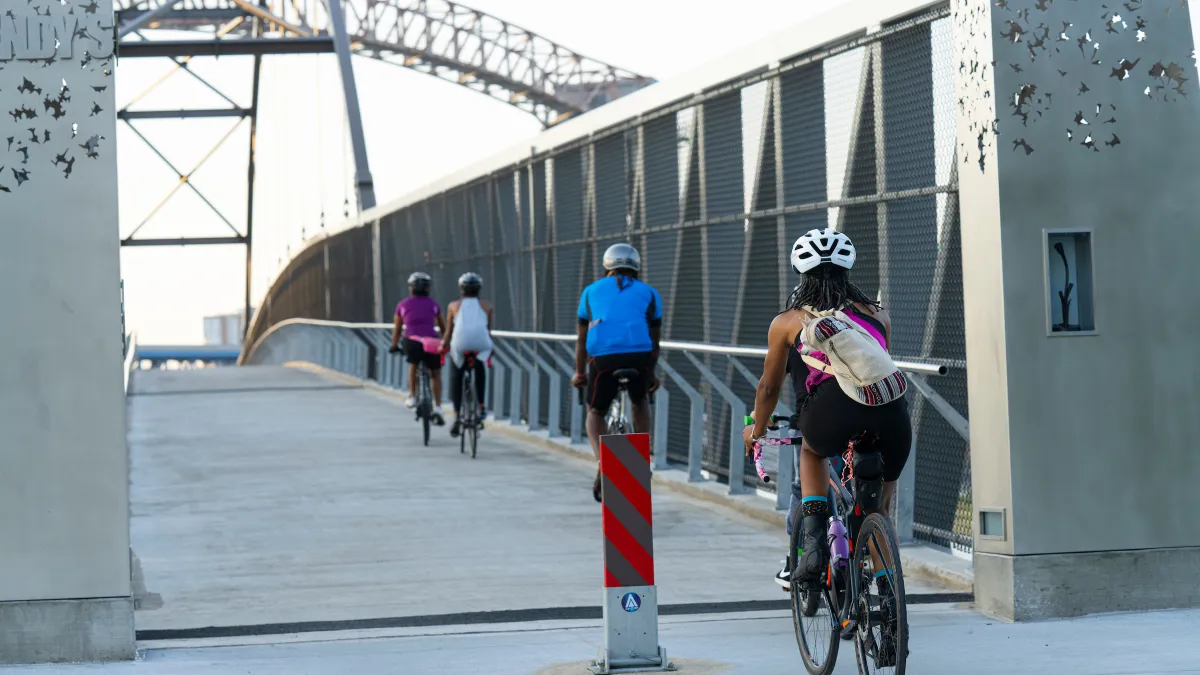 Bicyclists riding across a bridge along the Cleveland Foundation Centennial Lake Link Trail in Ohio.