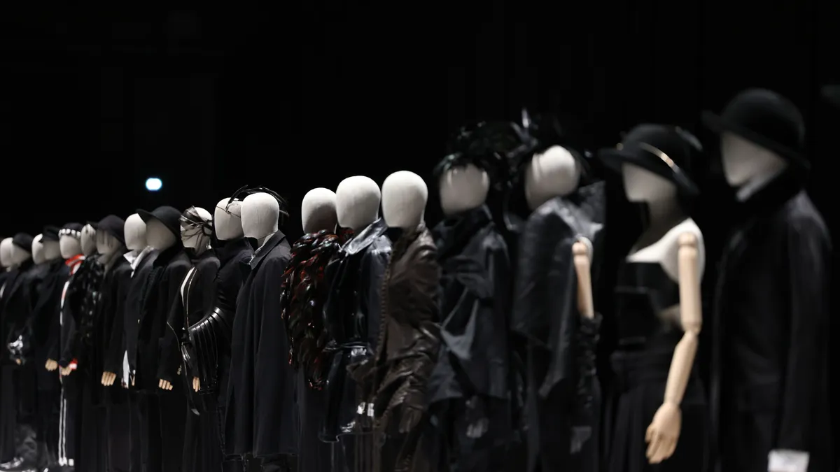 Mannequins wearing Ann Demeulemeester items are lined on a stage.